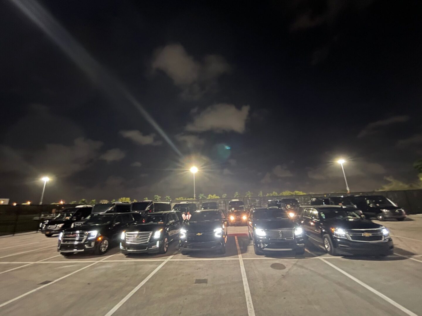 A parking lot full of cars at night.