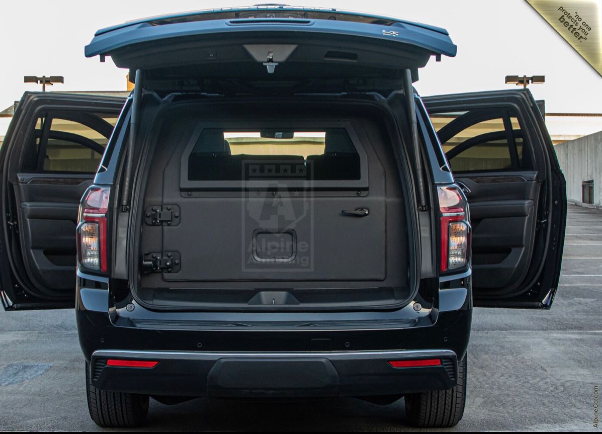 A black suv with its trunk open parked in the parking lot.