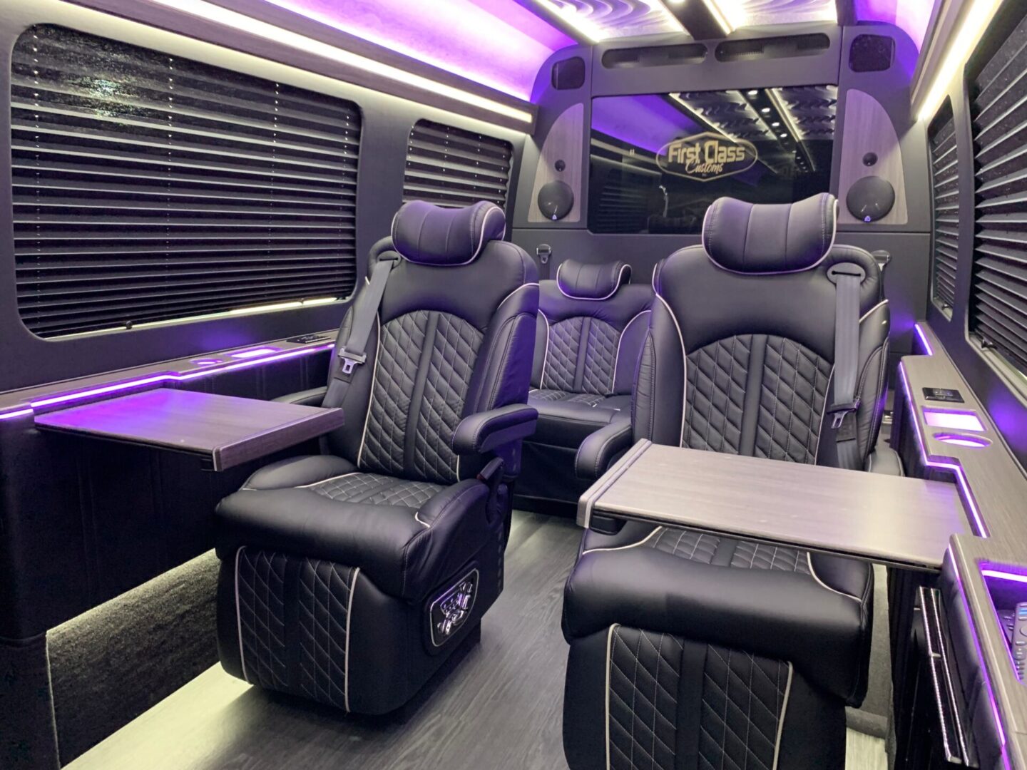 A bus with black leather seats and purple lights.