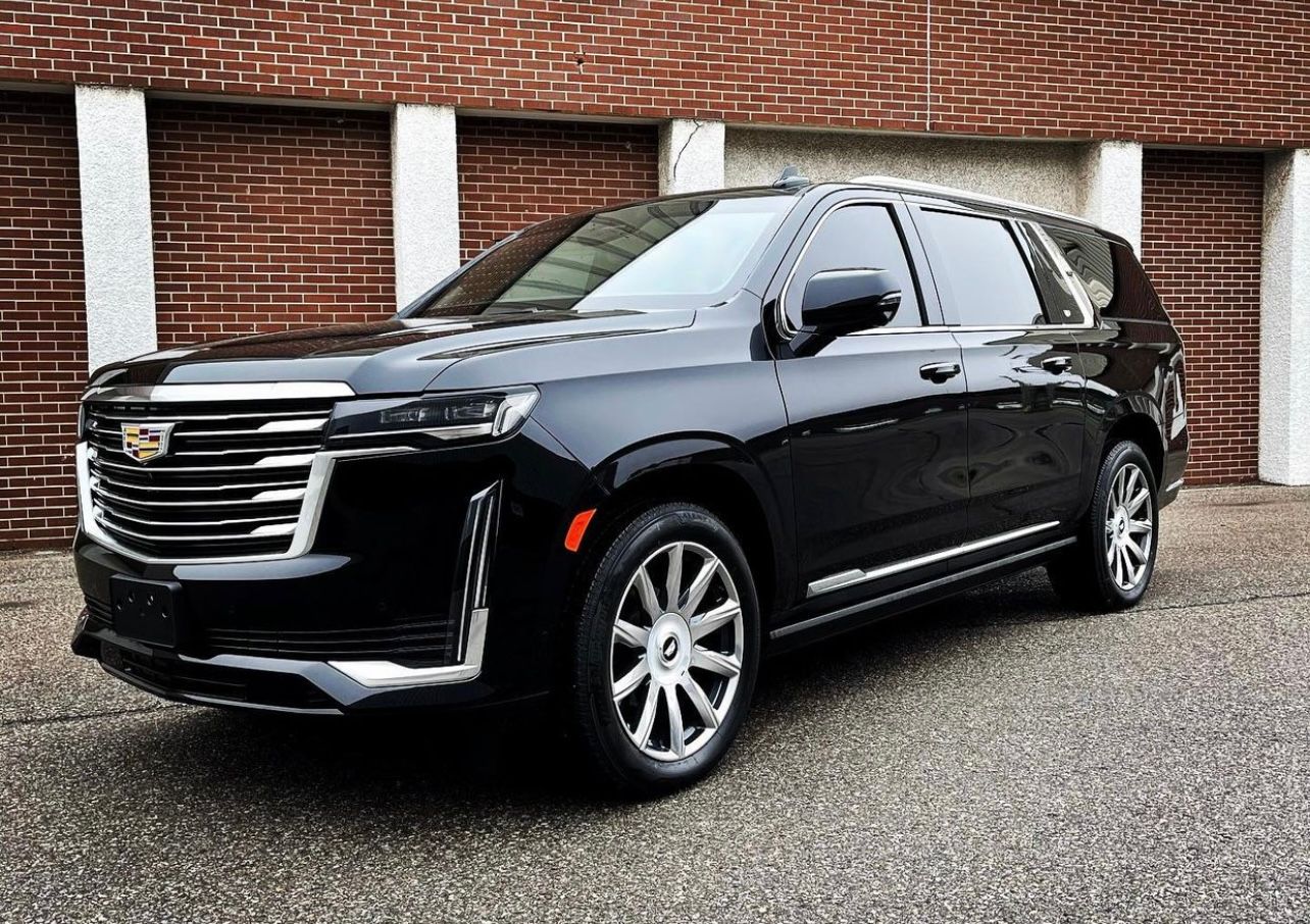 A black suv parked in front of a brick building.