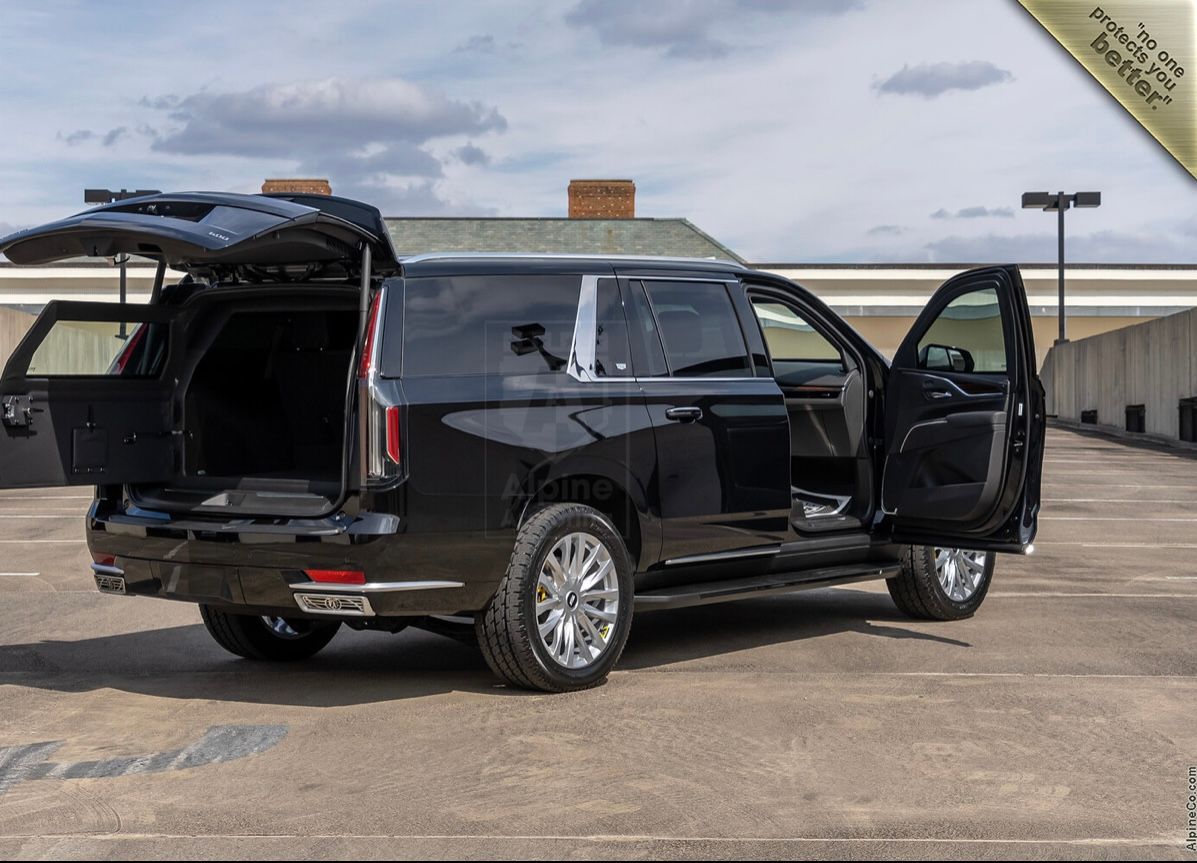 A black suv with its doors open parked in the parking lot.