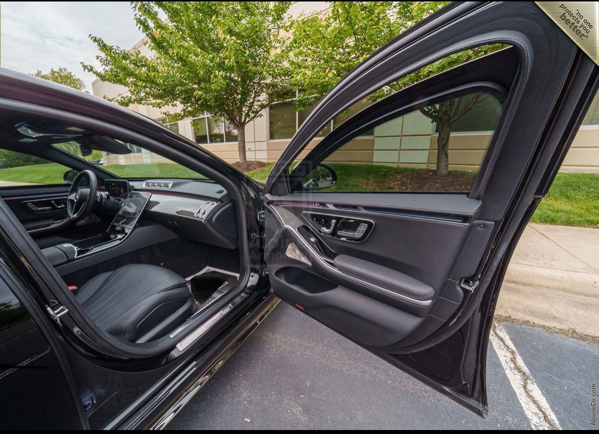 A car door open with the driver 's side view of the front passenger seat.