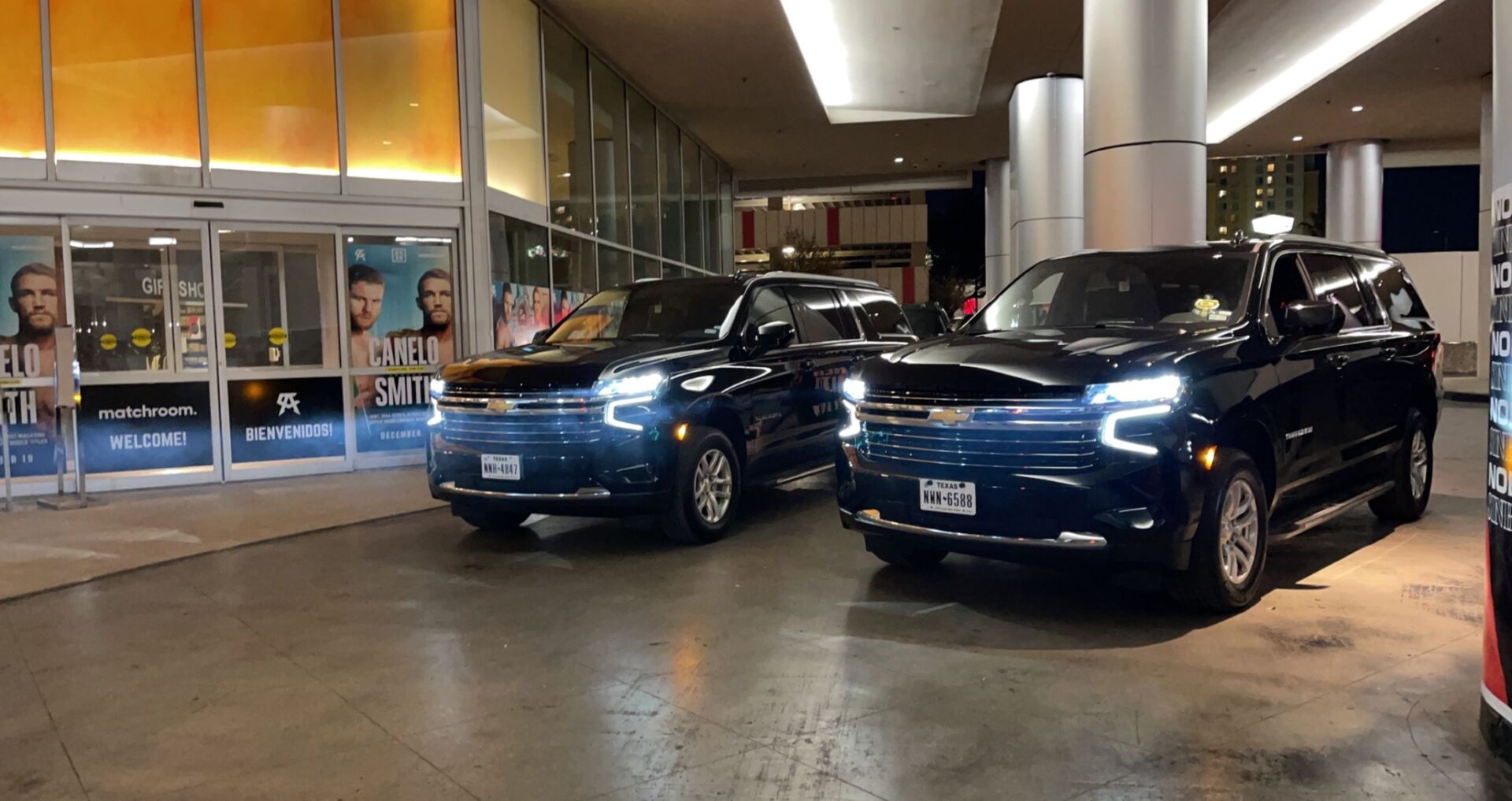 Two cars parked in a parking garage next to each other.