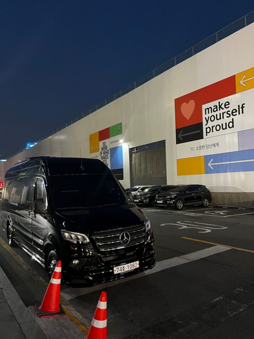 A van parked in front of a building with a large sign on it.