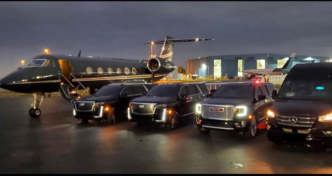 A group of cars parked in front of an airplane.