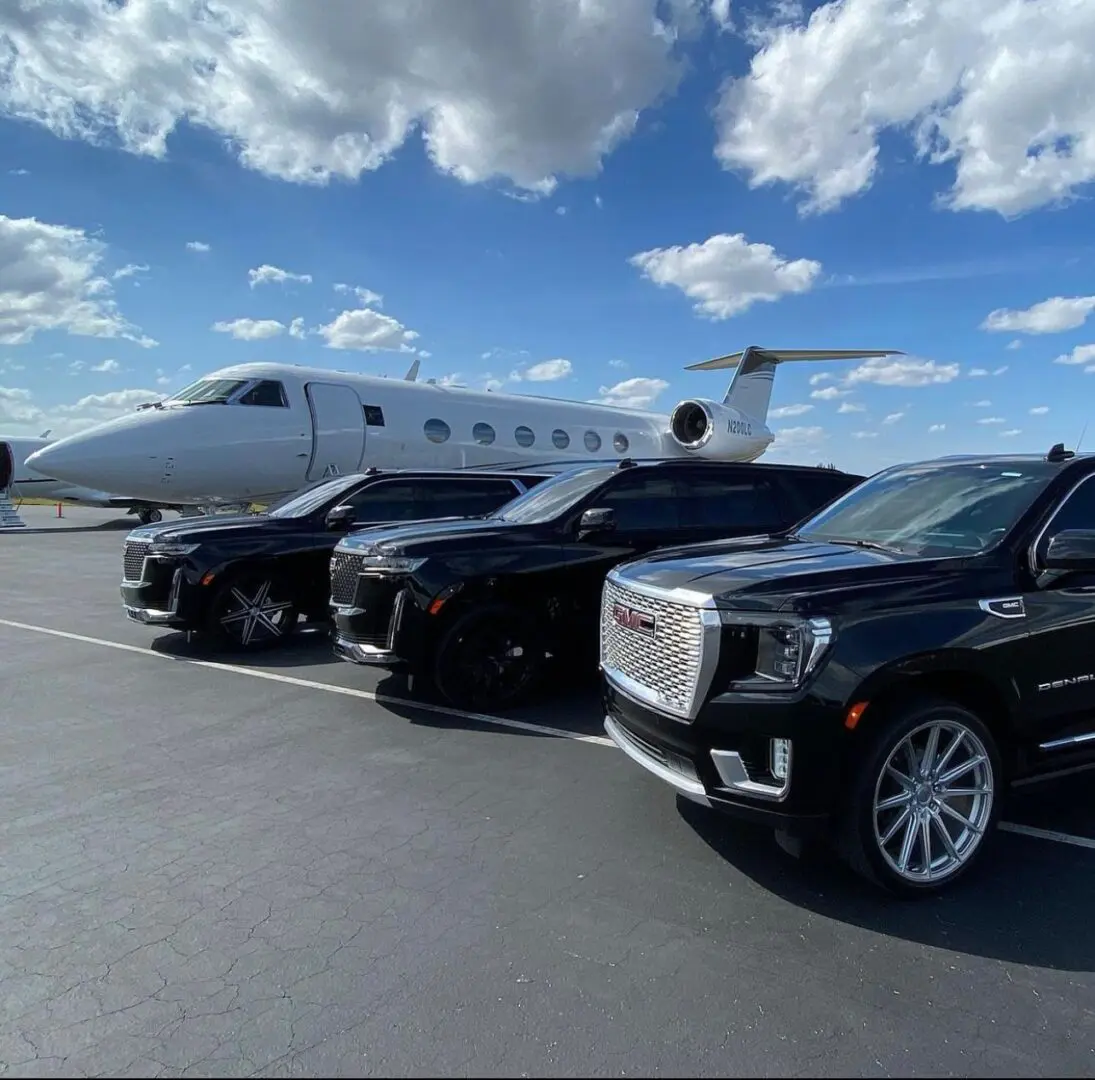 A group of cars parked in front of an airplane.