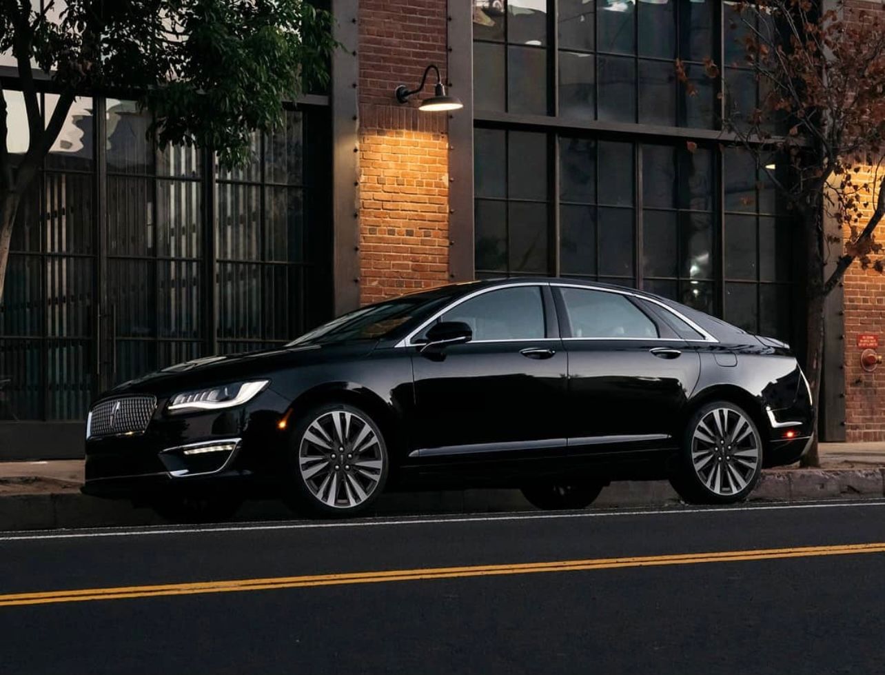 A black car parked on the side of a road.