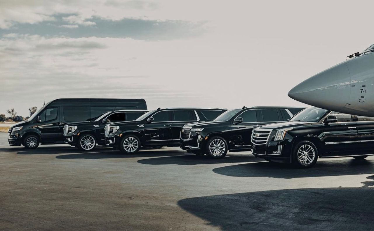 A group of black cars parked in a parking lot.