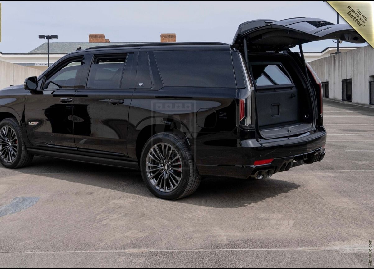 A black suv with its doors open parked in the parking lot.