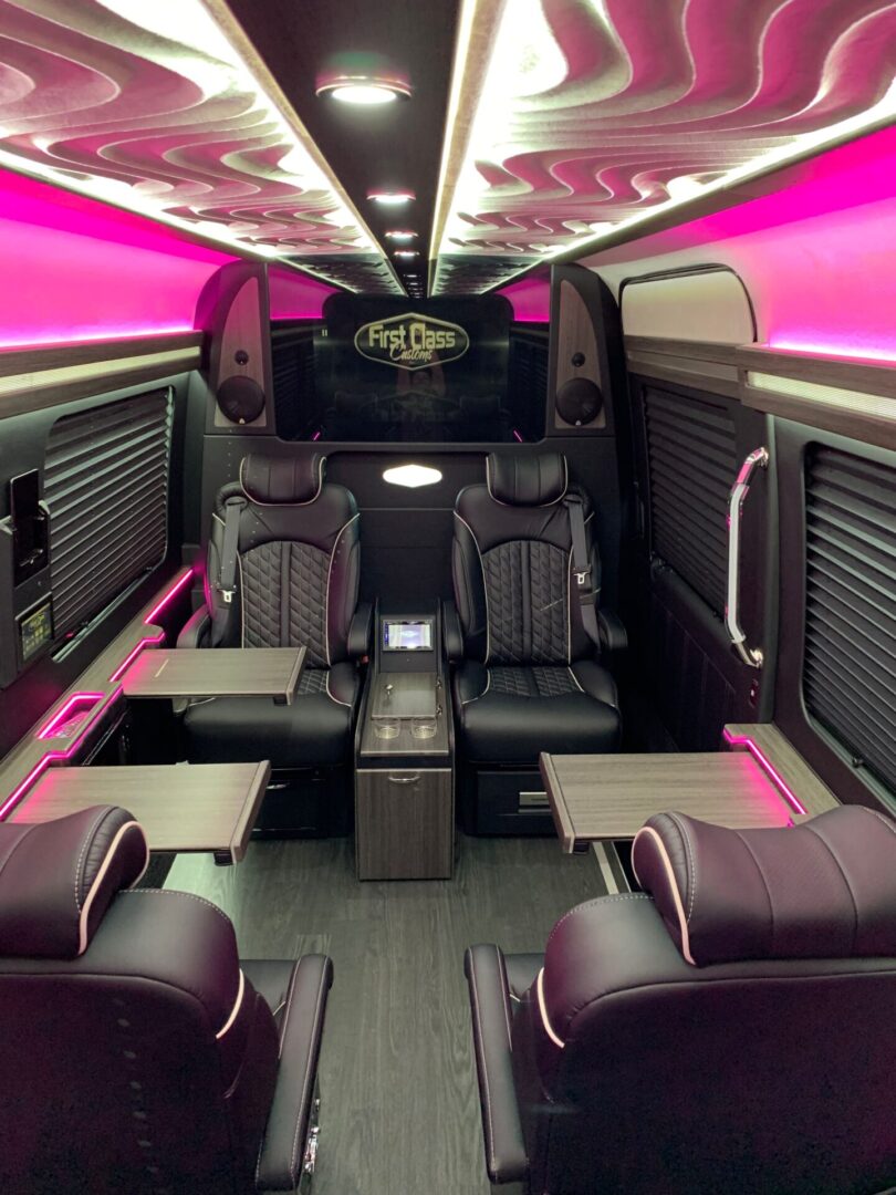 A bus with pink lights and black seats.