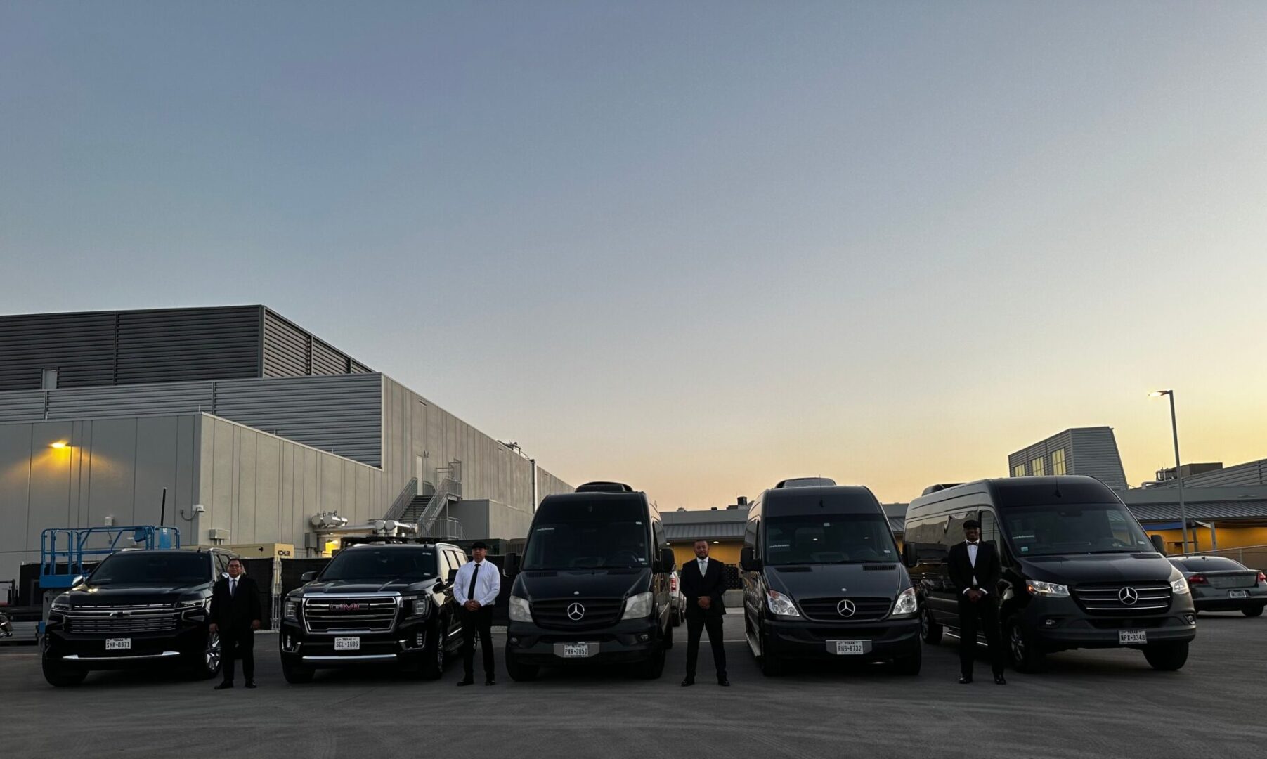 A group of people standing next to some vans.