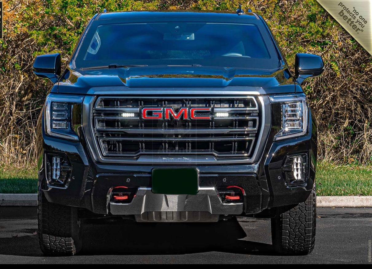 A blue truck with its front end in the sun.