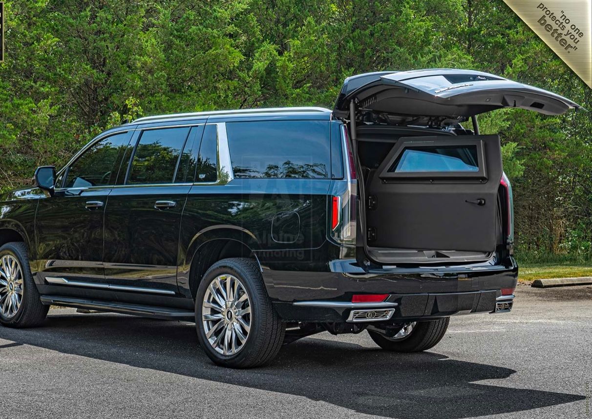 A black suv with its trunk open parked on the street.